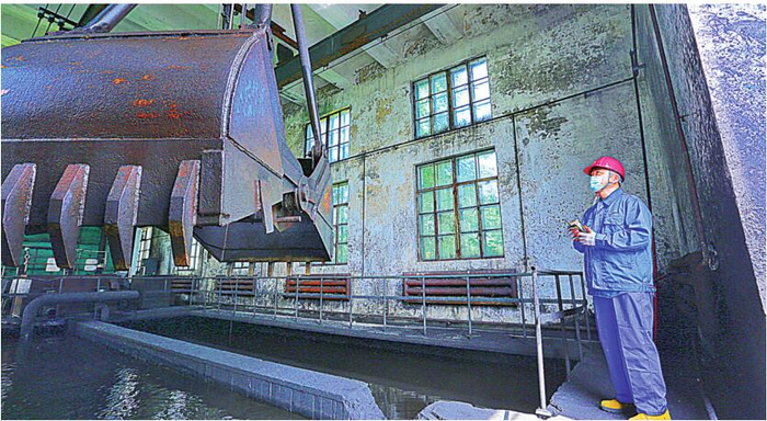 燃料部员工操作抓斗清理煤泥。