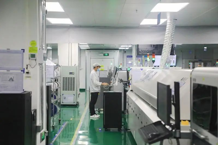 金溢科技有限公司的车间内工人正在调试自动化设备。刘乙丁/摄