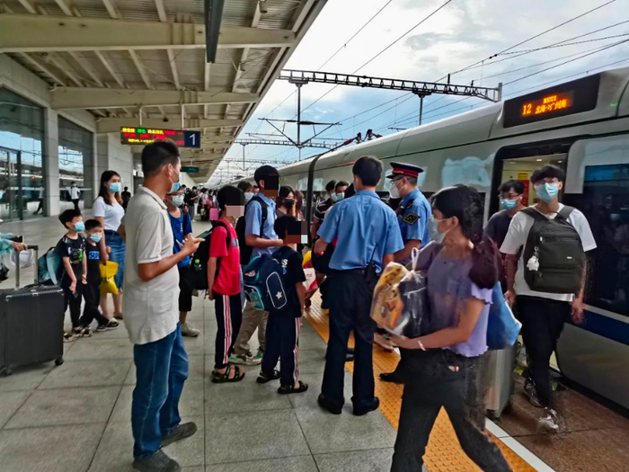 △车站工作人员与列车长交接，并安排小男孩一家乘坐动车前往广州南站。