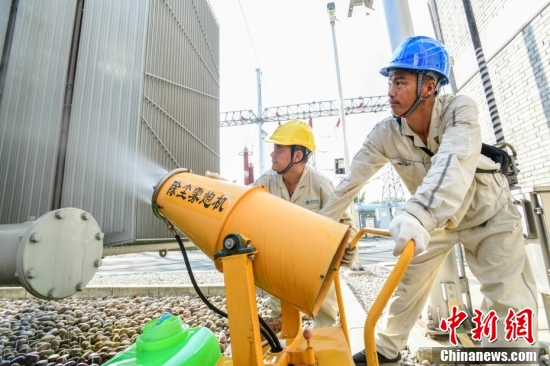 图为国网江津区供电公司对9个变电站温度超过70摄氏度的变压器采用雾炮机水喷和水冲两种方式实施物理降温。王化全 摄