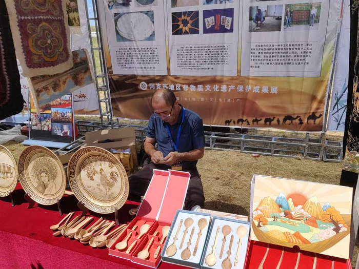 非遗传承人艾尔肯·吾甫尔正在展示库休克（木勺）制作技艺。耿丹丹摄
