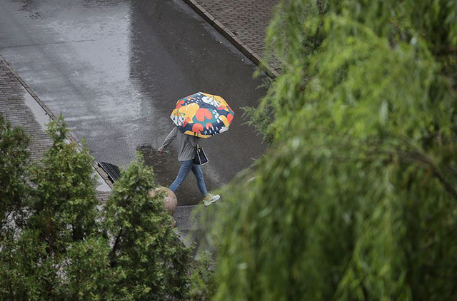 7月12日，八里庄东里，阴雨降温，雨中的路人穿上了外套。新京报记者 薛珺 摄