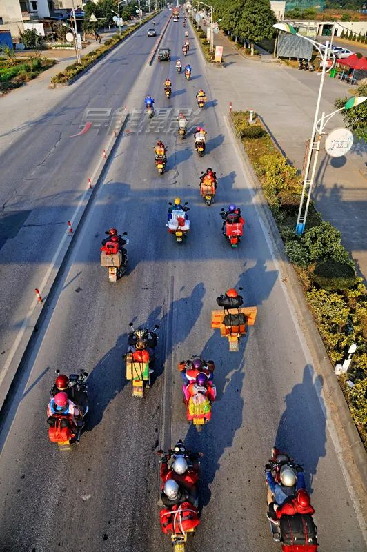 △昔日春运期间，不少外出务工人员与同乡组成摩托车队，三五成群，结伴踏上返乡之路，成为春运路上的一道独特风景线。何异能 摄