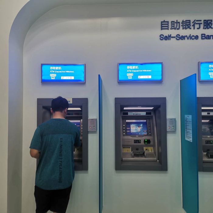 （正在ATM机办理业务的市民；时代财经拍摄）