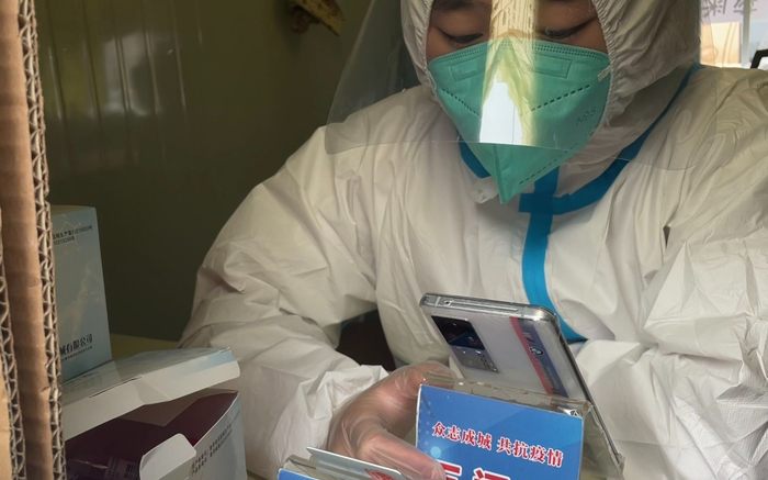 7月19日下午，中国传媒大学东门处核酸检测点，工作人员正在录入信息。新京报记者 耿子叶 摄