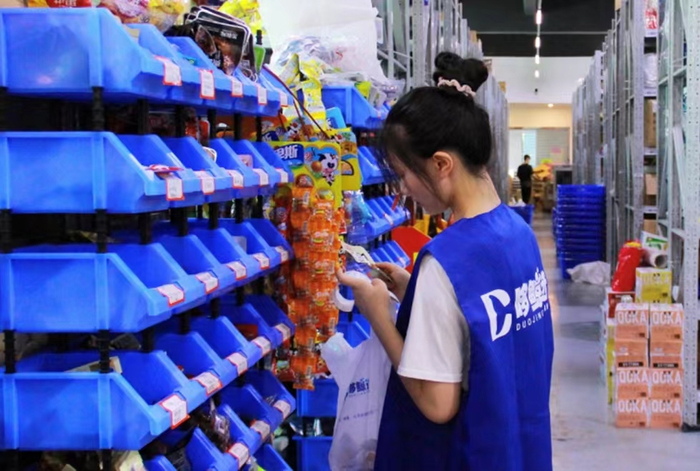▲“哆鲸选”店员正在仓内拣货