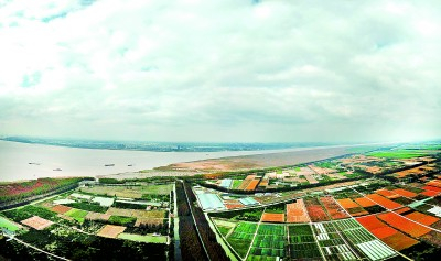     长江从崇明岛（前）和江苏省海门市之间流向大海。新华社发