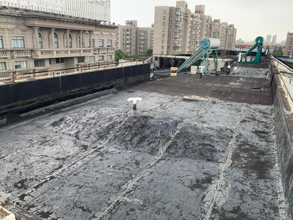 △物业在屋顶挖坑补漏之后留下不规则大小的“大包”。