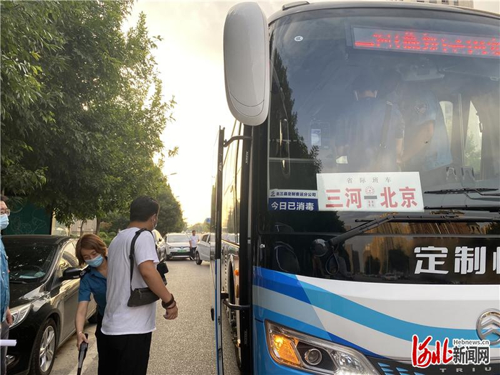 7月25日，在三河市星河园小区门口，安全员正在对乘客进行安全检查。