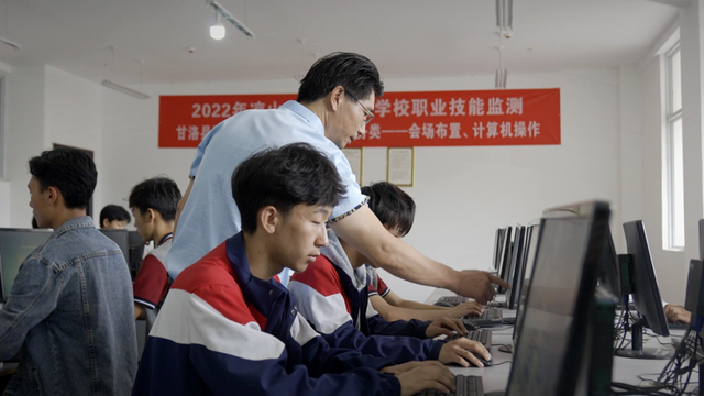 图为正在给学生上课中的何成文。