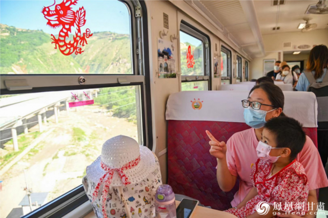 “富民号”上，一位母亲正在向她的孩子讲述剪纸艺术和龙的故事。徐凌波 摄