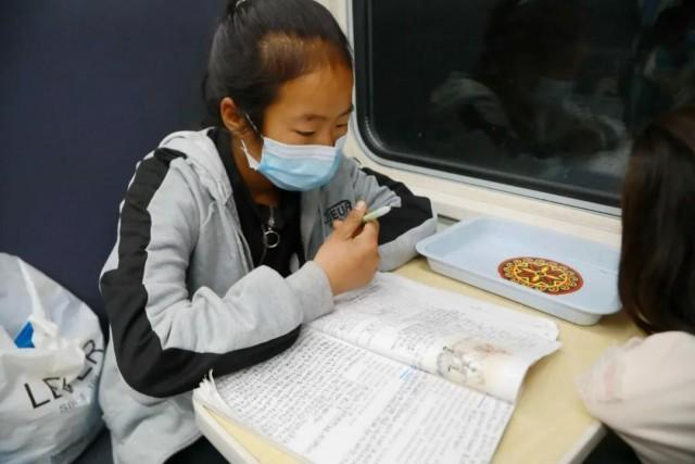 图为5月17日，5633次列车上，曲木史古莫正在学习《木兰辞》。