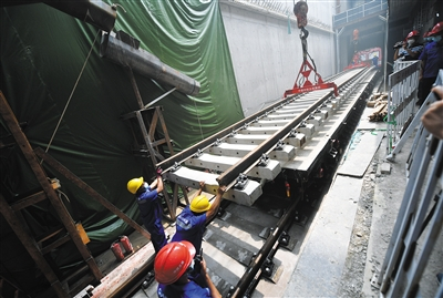 7月26日，地铁12号线北岗子铺轨基地内，施工人员正在对轨排进行吊装。