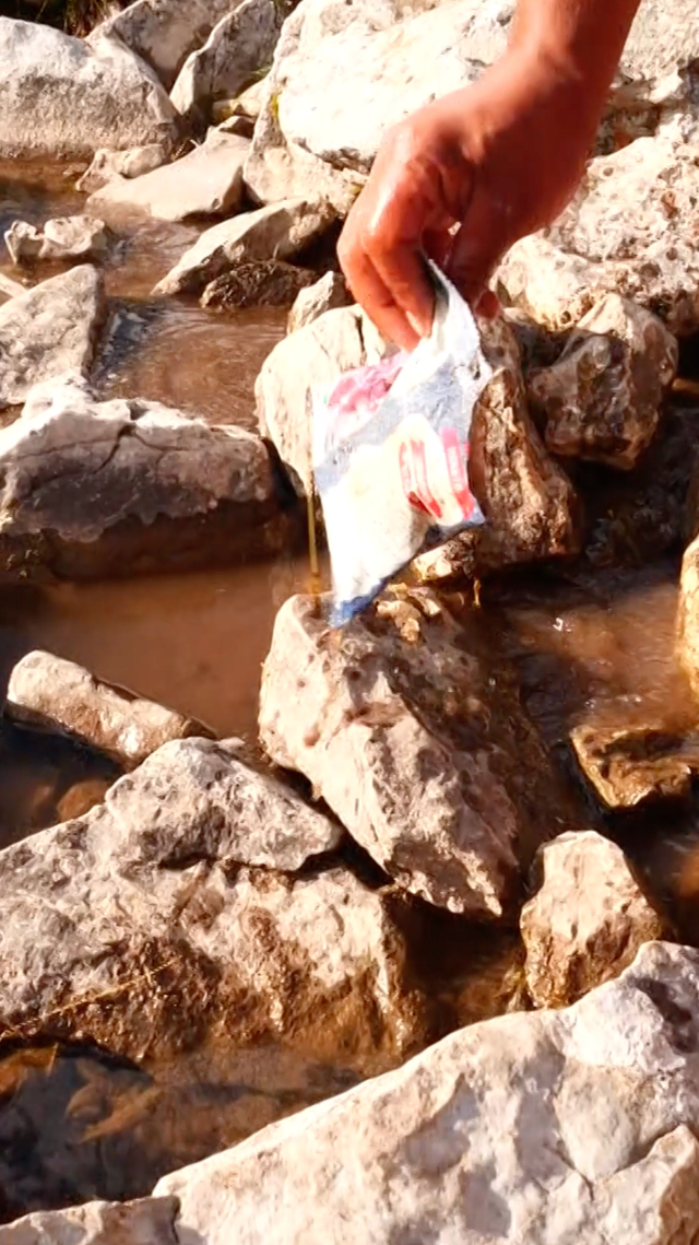 ▲当地旅游从业者在河边捡拾垃圾。 受访者供图