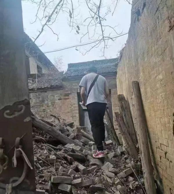 2022年4月，赵英杰在两项调查时查看被雨水冲塌的民宅。受访者供图