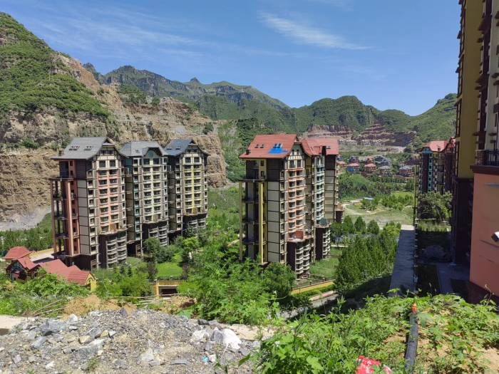 华银天鹅湖景区内，两栋楼背靠高山，处在洼地。于丽丽摄