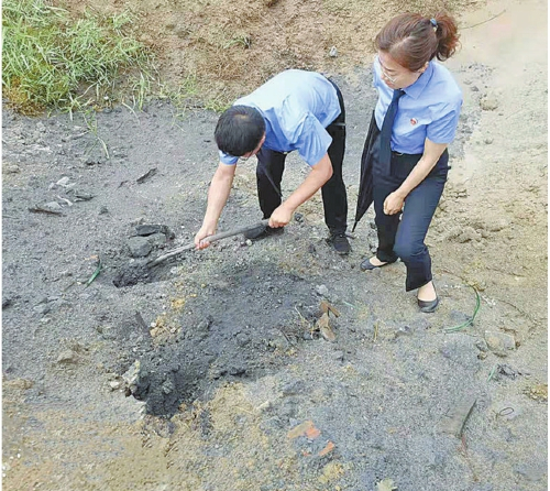 　　　图为检察官在调查周边污染物非法倾倒情况