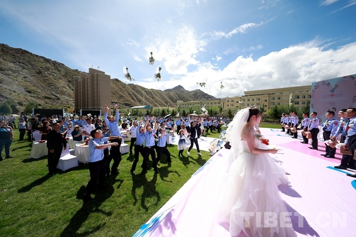 图为8月5日，“边守·边爱”集体婚礼现场新娘向未婚来宾抛花球 摄影：何宇恒