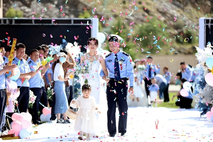图为8月5日，“边守·边爱”集体婚礼现场“新人”们在战友们的祝福中登台 摄影：胡俊浩