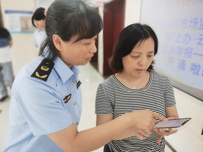 市场监管人员指导群众使用一码通系统。资料图片