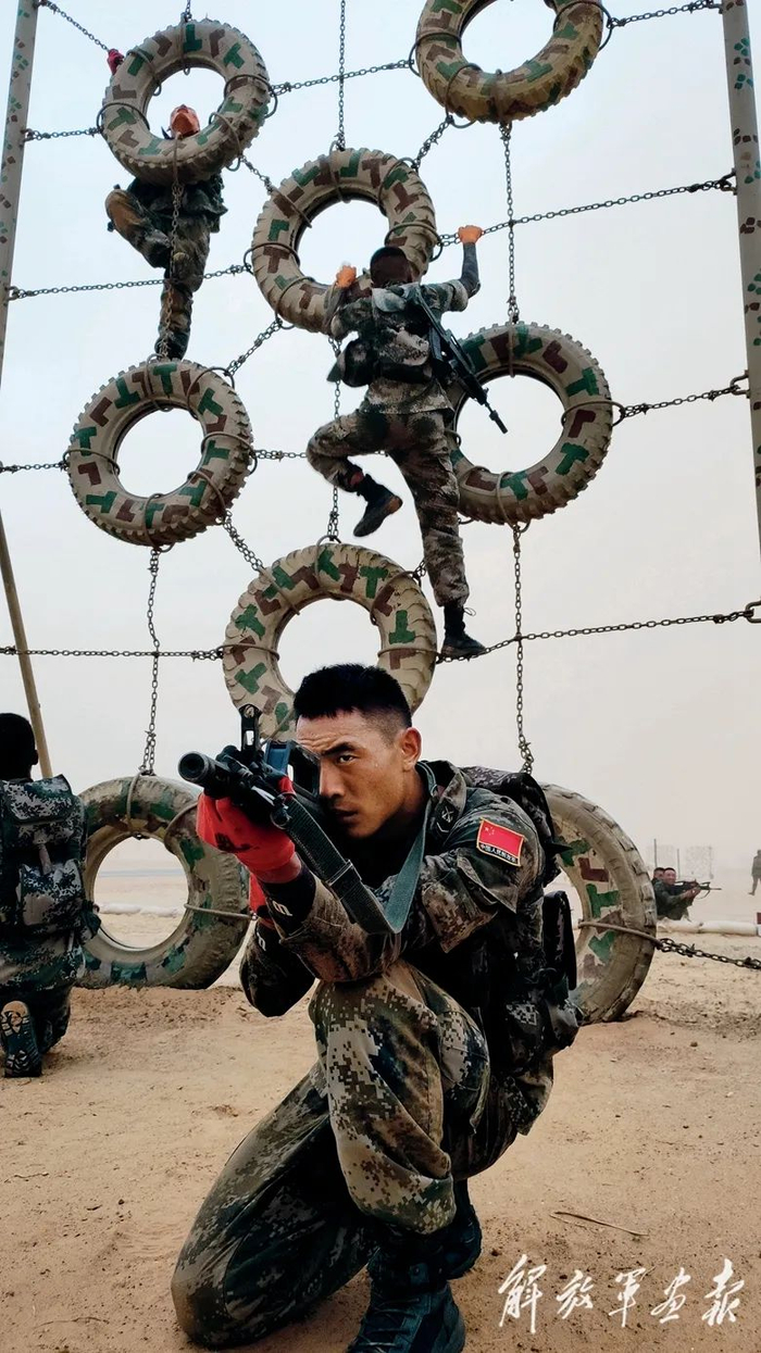 在“侦察尖兵”项目比赛中，我军参赛队员交替掩护迅速攀登障碍网。（摄影/衡 宇）