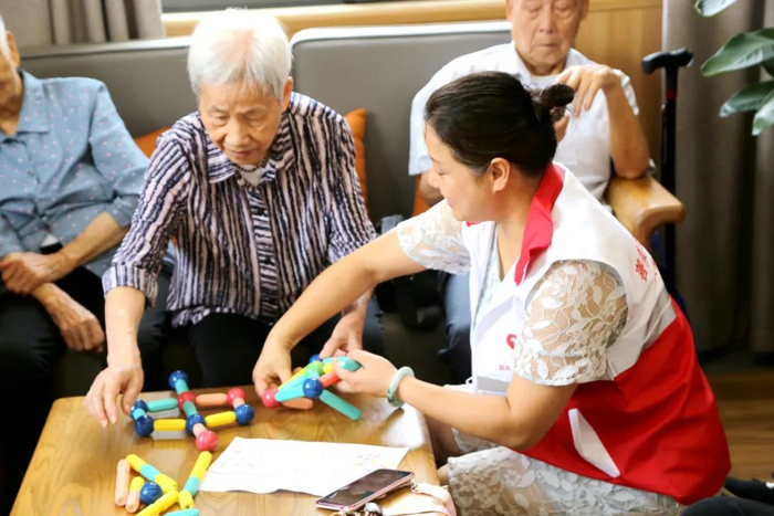 社工志愿者在指导老人做康复。