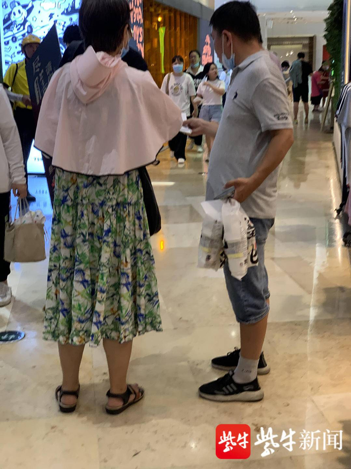 　疑似排队老人将奶茶交给黄牛