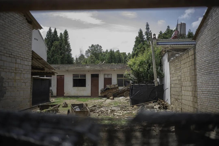 　　这个“家”已经很久没有人生活。院子里长出了杂草，大门口拉起一块黑色的围挡布，想把内外两个世界隔开（金海 摄）