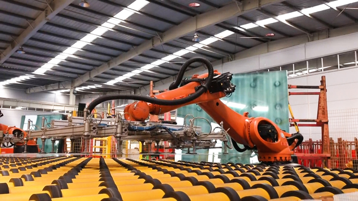 自动化生产线上的机械手臂在装运玻璃。