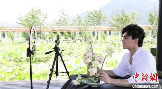 王胡傲在直播间推销鲜切荷花。李云升 摄
