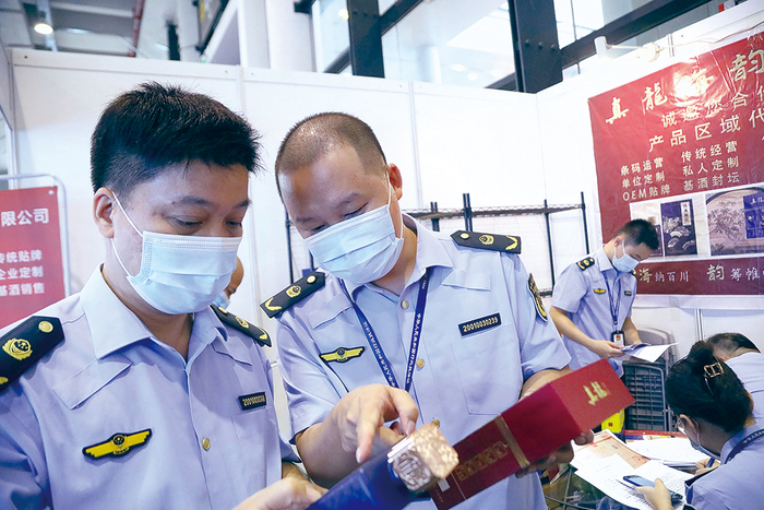 南宁市市场监管局公平交易稽查局执法人员现场查看涉嫌侵权的外包装，并对涉案物品进行取证。