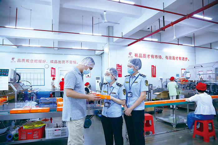 南宁市市场监管局经开分局执法人员在一家食品生产企业进行现场检查。