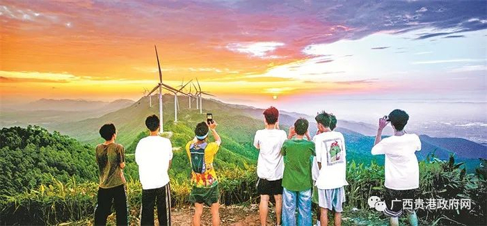 游客在港北区百花山大风车景点观赏日出。（李成伦摄）