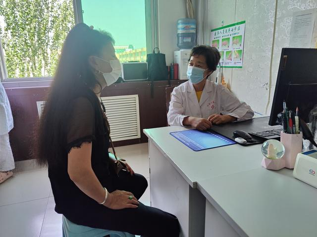 2022年8月1日，准格尔旗妇幼保健院，段仙芝（右）正在问诊一名前来做宫颈癌筛查的女性。 新京报记者 吴小飞 摄