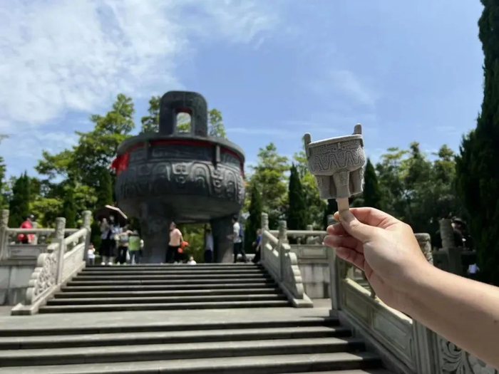 △不少市民游客手持文创雪糕，在肇庆地标建筑前留影，成功解锁“打卡”新姿势。图源 星湖美美