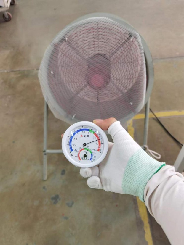 　图说：记者手持温度计在防爆扇前实测温度为35℃。