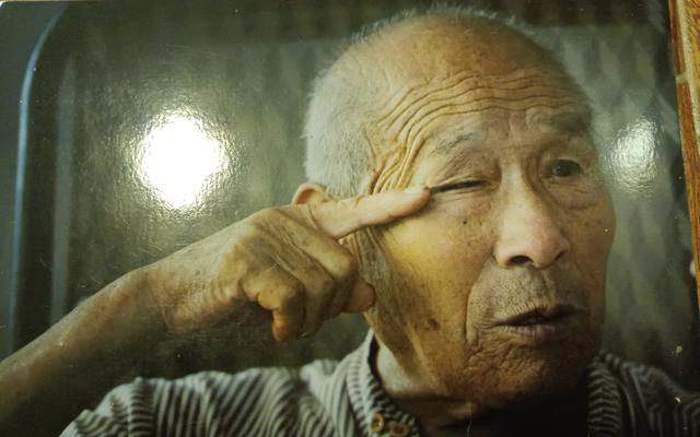 2010年，王在祯回忆在日往事时擦拭眼泪。受访者供图