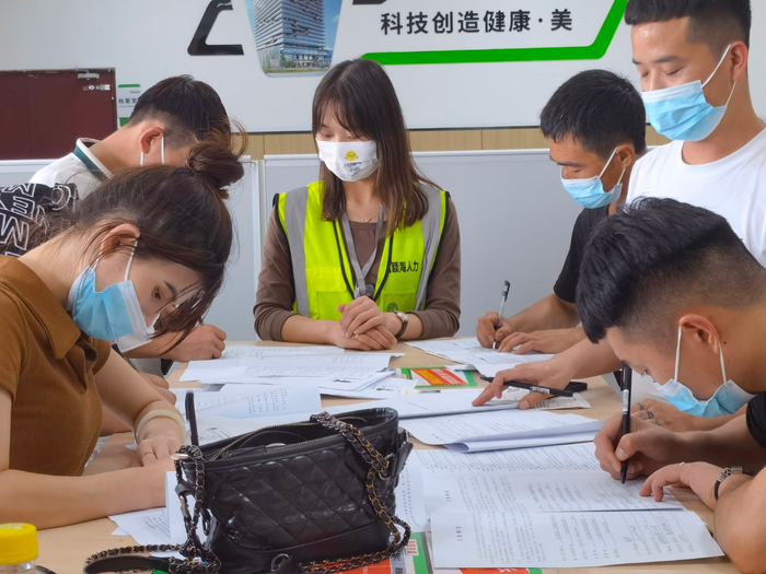 歌尔股份靠直播带岗已经招聘了5000多人。图为工作人员正在帮助求职者填表。