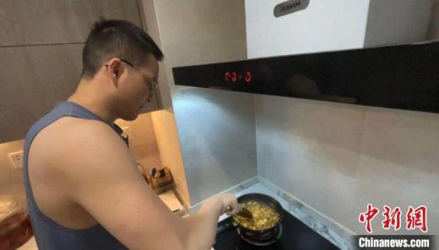 成都市民魏谨言在厨房做饭。　受访者供图