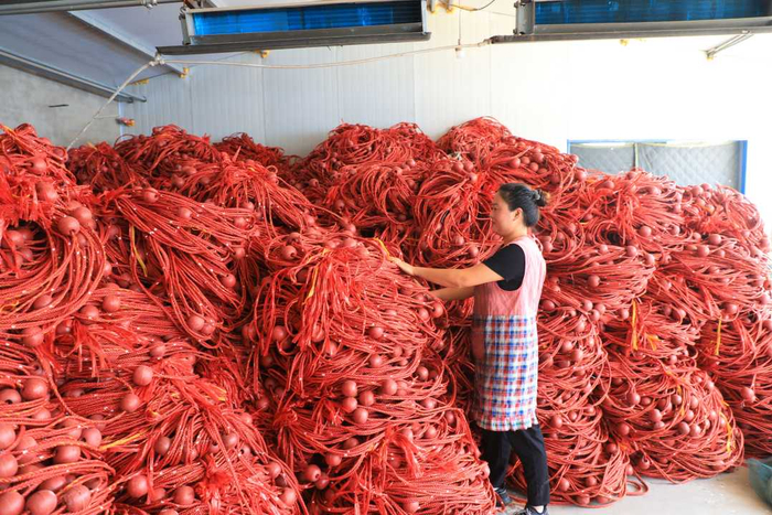 工人在河北省滦南县程庄镇东胡家坡村一家网具加工企业库房内摆放网具。