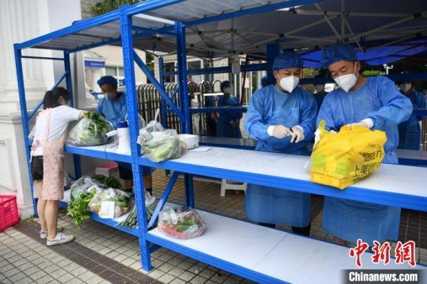 小区工作人员准备将外卖物资送到小区内。　张浪 摄