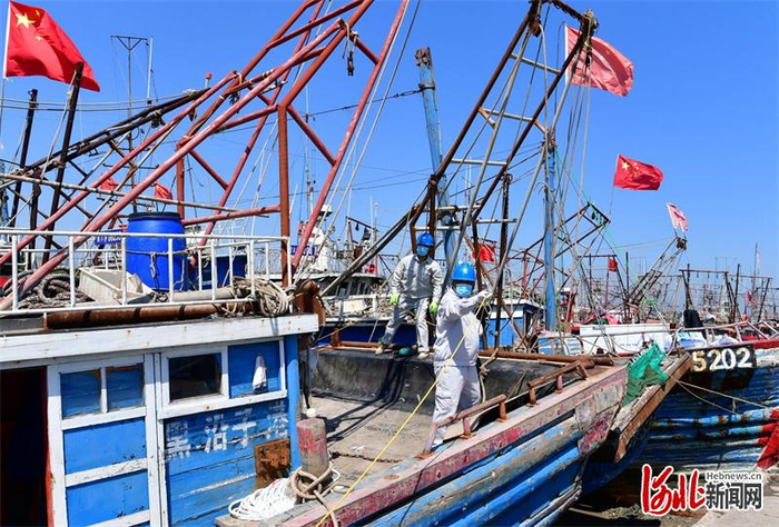 国网唐山供电公司丰南区黑沿子镇供电所员工来到黑沿子镇渔港码头，为渔船搭接照明低压线路。通讯员刘浩学摄