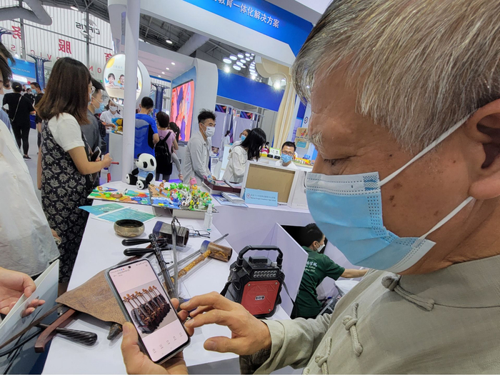 图为刘正辉向记者展示中国样式仿生皮民族低音乐器。