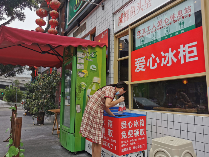 赵春燕正在整理爱心冰柜里的矿泉水和饮料。工人日报-中工网记者李娜 摄