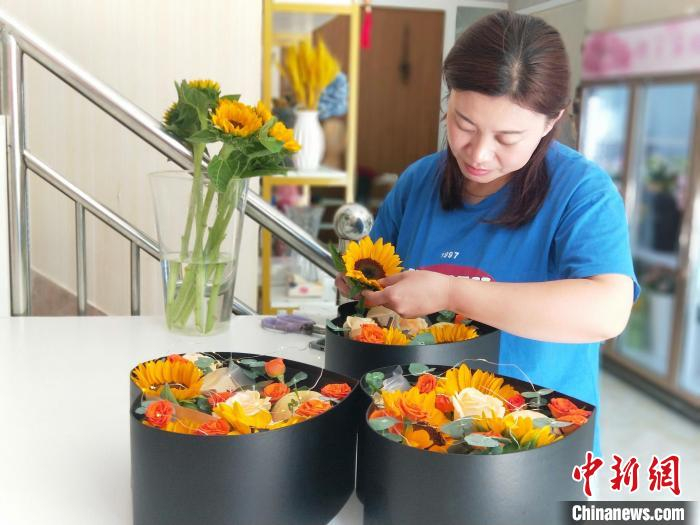 花卉销售点工作人员在制作鲜切花礼品盒。赵国华摄