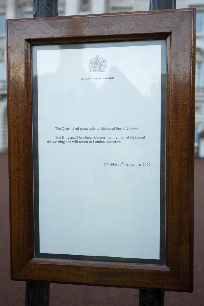 当地时间2022年9月8日，英国伦敦，王室工作人员将英国女王伊丽莎白二世去世的公告挂在白金汉宫的大门上。图据视觉中国