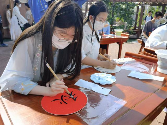 北京四中璞瑅学校的学生身穿传统服饰在画团扇。新京报记者 杨菲菲 摄