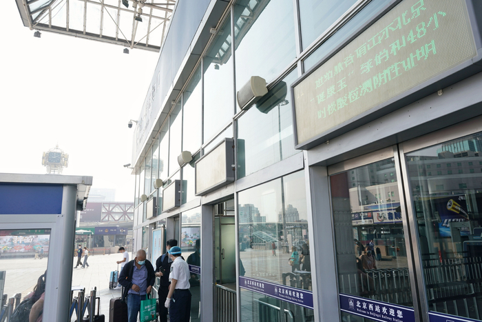 北京西站的户外屏幕上滚动播放着进站需持有健康宝绿码和48小时内核酸阴性证明的要求。新京报记者 王贵彬 摄