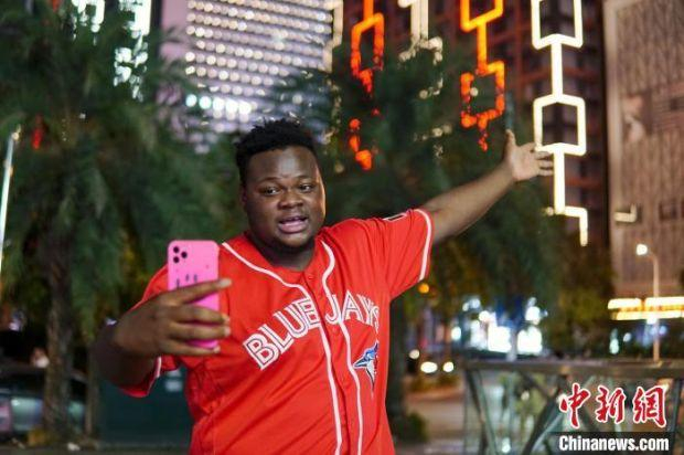 图为博密正在柳州市街头拍摄vlog。　韦国政 摄