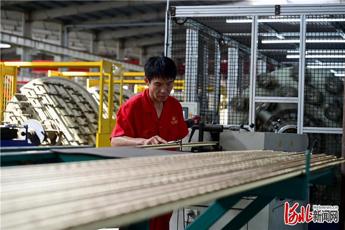 近日，在景县河北远大集团车间内，工人正检查编织成型的胶管管径。 河北日报记者 焦 磊摄